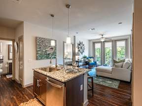 A kitchen with a granite countertop and stainless steel appliances.