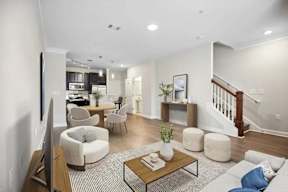 A living room with a staircase in the background.