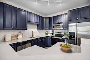 A kitchen with dark blue cabinets and white countertops.
