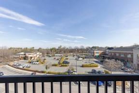 A parking lot with several cars and a building in the background.