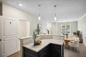 A modern kitchen with a large island and a dining area.