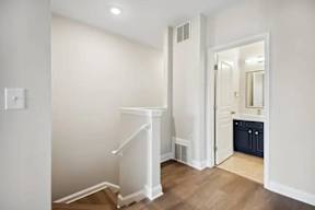 A white staircase in a room with a light switch on the wall.