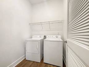 Two white front loading washing machines in a laundry room.