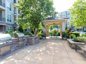 A patio area with a grill and seating area.