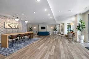 A spacious room with wooden flooring and a long table with chairs.