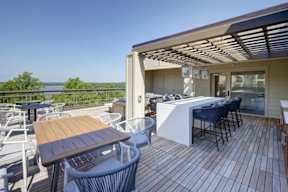 A wooden deck with a table and chairs overlooking a body of water.