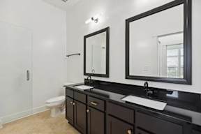 A bathroom with a black countertop and a white toilet.