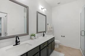 A bathroom with a white sink and black cabinetry.