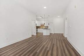 A room with wooden flooring and white walls.