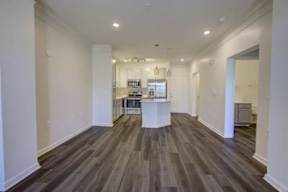 A long hallway with wood floors and white walls.