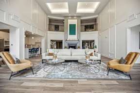 A living room with a white sofa, two chairs, and a coffee table.