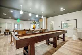 A pool table is in the middle of a room with a wooden floor.