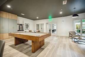 A room with a pool table and a chair.