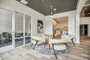 A modern dining room with a glass table and chairs.