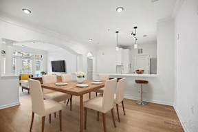 A dining room with a wooden table and chairs.