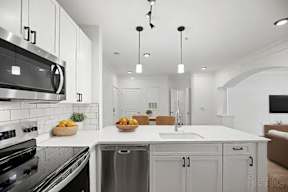 A modern kitchen with a stainless steel oven and a white countertop.