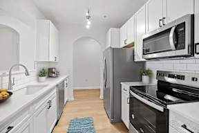 A kitchen with white cabinets and a black stove top oven.