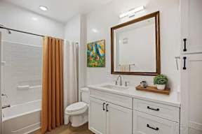 A bathroom with a white sink and a white toilet.