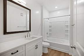 A white bathroom with a toilet, sink, and bathtub.