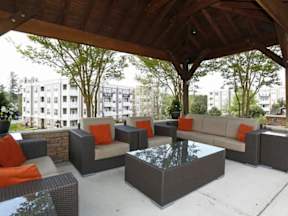 A patio with a table and chairs under a roof.