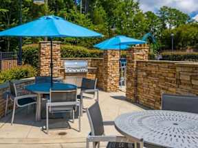 A patio with a table, chairs and umbrellas.