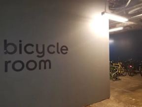 A bicycle room sign is illuminated by a light.