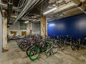 A room full of bicycles in a building with exposed pipes.
