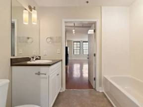 A bathroom with a white tub and sink.