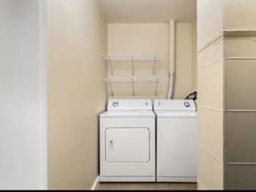 Two white front loading washing machines in a laundry room.
