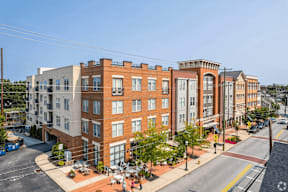 A street view of a city with a red brick building in the foreground.