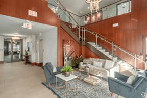 A living room with a staircase and exit signs.