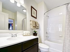 A bathroom with a white sink, toilet, and shower.