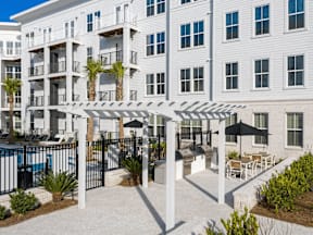 A white building with a pool and patio area.