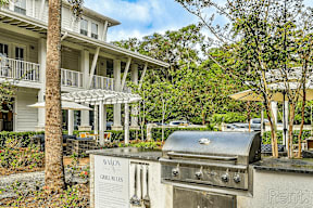 A grill with a sign that says "Grill Rules" is in front of a building with a balcony.