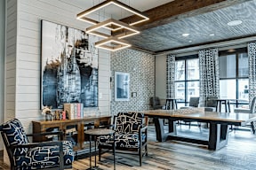 A modern living room with a large abstract painting on the wall and a wooden floor.