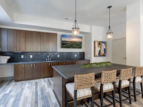 A kitchen with a large island and chairs.