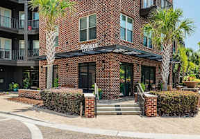 A brick building with a black awning and a sign that says