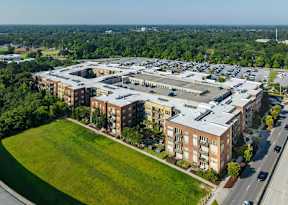 A large, multi-story building complex with a parking lot in front.