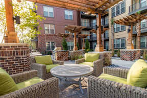 A patio with a table surrounded by chairs and a pergola.
