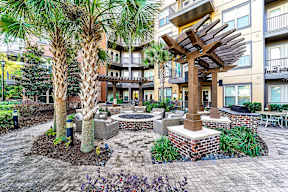 A courtyard with a fire pit and a tree.