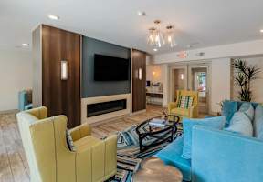 A living room with a yellow chair and a blue couch.
