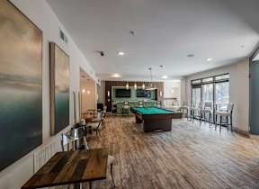 A room with a pool table and a painting on the wall.