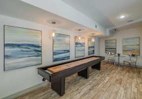 A room with a pool table and paintings on the wall.