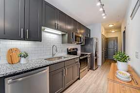 A kitchen with dark brown cabinets and stainless steel appliances.