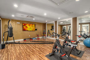 A gym with exercise equipment and a painting on the wall.