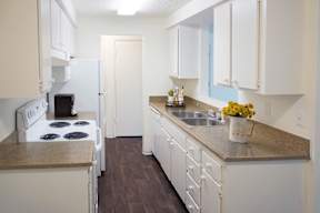 A kitchen with white cabinets and a white stove at apartments in Redmond, WA.