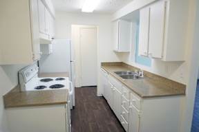 a kitchen with white cabinets and a sink and a refrigerator