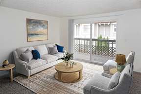 A living room with a grey couch, a wooden coffee table, and a painting on the wall in apartments in Redmond, WA..