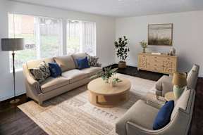 A living room with a couch, a coffee table, and a side table at Heritage Woods Apartments in Redmond