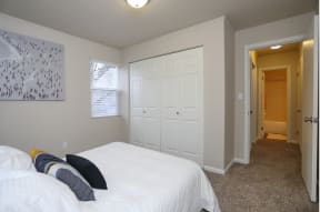 Bedroom with full side bed and 2 panel closet doors.at Woodhaven, Washington